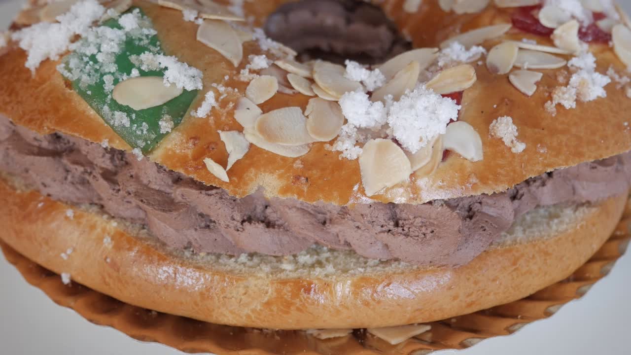 сладкий десерт roscón de reyes с миндалем и конфискованными фруктами в праздничном настроении