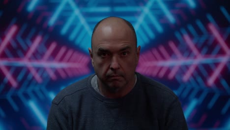hombre blanco de mediana edad mirando a la cámara con una mirada en blanco con un fondo colorido en movimiento