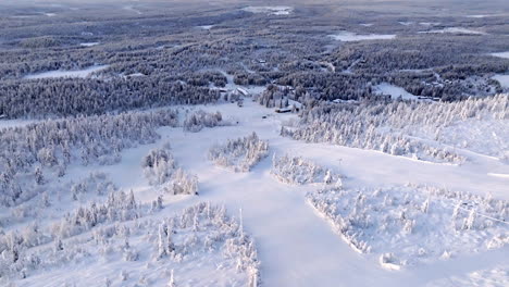 aerial overview over the icy slopes of sallatunturi, winter sunrise in finland