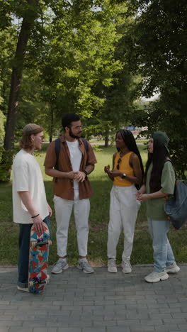 four young adults chatting and socializing in a park