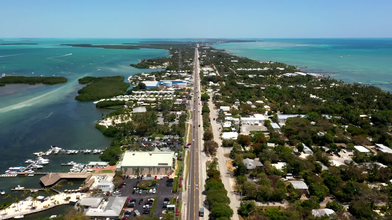 High aerial angle of highway slicing through blue ocean in sunny Florida Keys