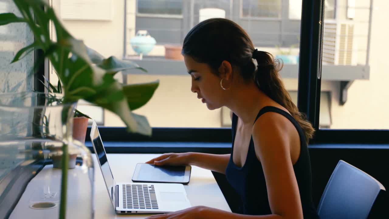 mujer ejecutiva usando una computadora portátil en el escritorio 4k