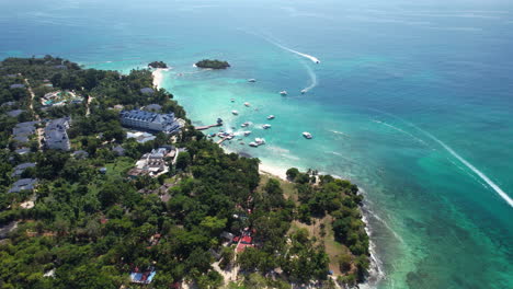 epic aerial view descending and tilting the camera on a caribbean touristic island with boats and buildings, dominican republic