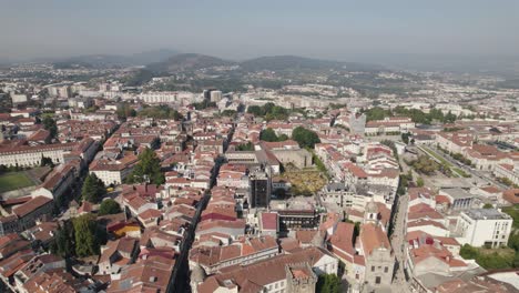 Drone-flying-over-Braga-rooftops,-Portugal.-Aerial-forward