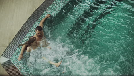 romantic couple relaxing at whirlpool bath. beautiful couple relaxing in water