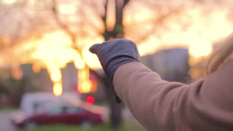 Closeup-of-female-hands-wearing-winter-gloves,-going-out-at-sunset,-cold-weather