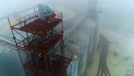 aerial view of grain silos in foggy conditions