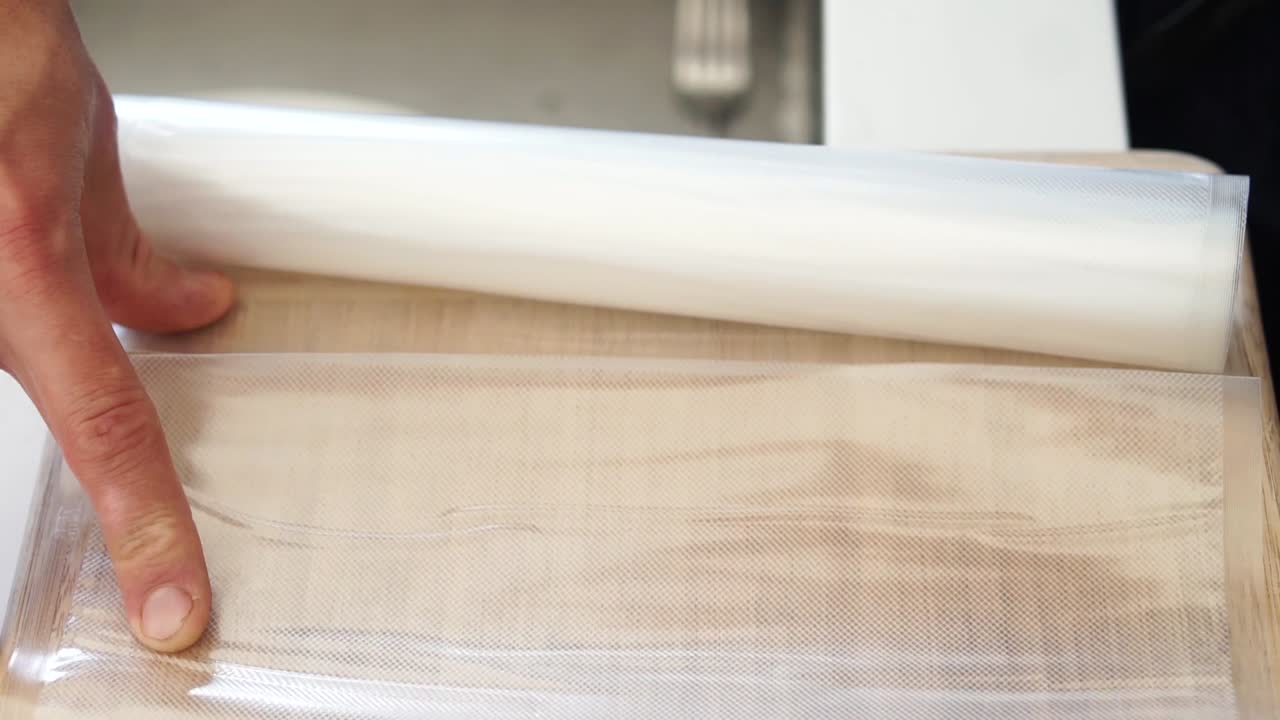 chef cortando un trozo de plástico para sous vide