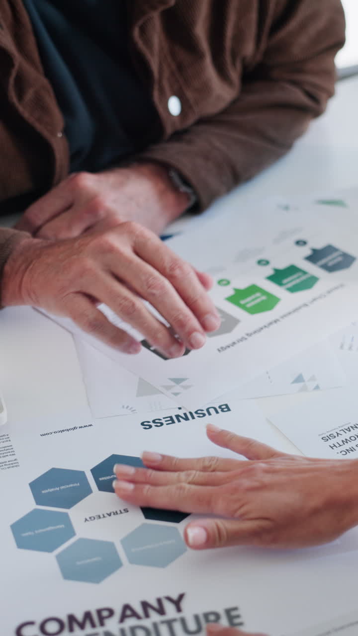 Close Up of People Discussing Business Documents and Financial Reports