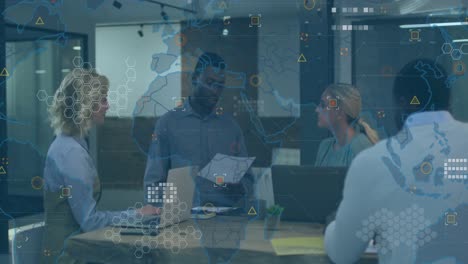 Animation-of-world-map-over-african-american-man-discussing-with-diverse-colleagues-at-office