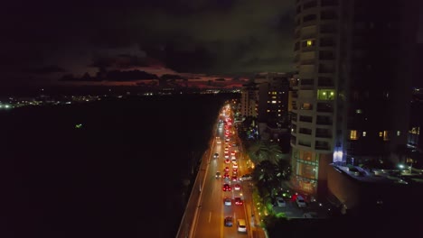 aerial over anacaona avenue traffic after sunset in santo domingo