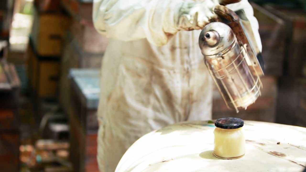 양봉가 들 이 벌 들 을 벌집 에서 멀리 흡연 하고 있다