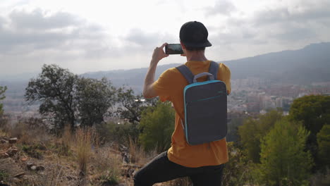 hombres jóvenes turistas en una caminata por la montaña filmando el paisaje con una cámara de teléfono inteligente