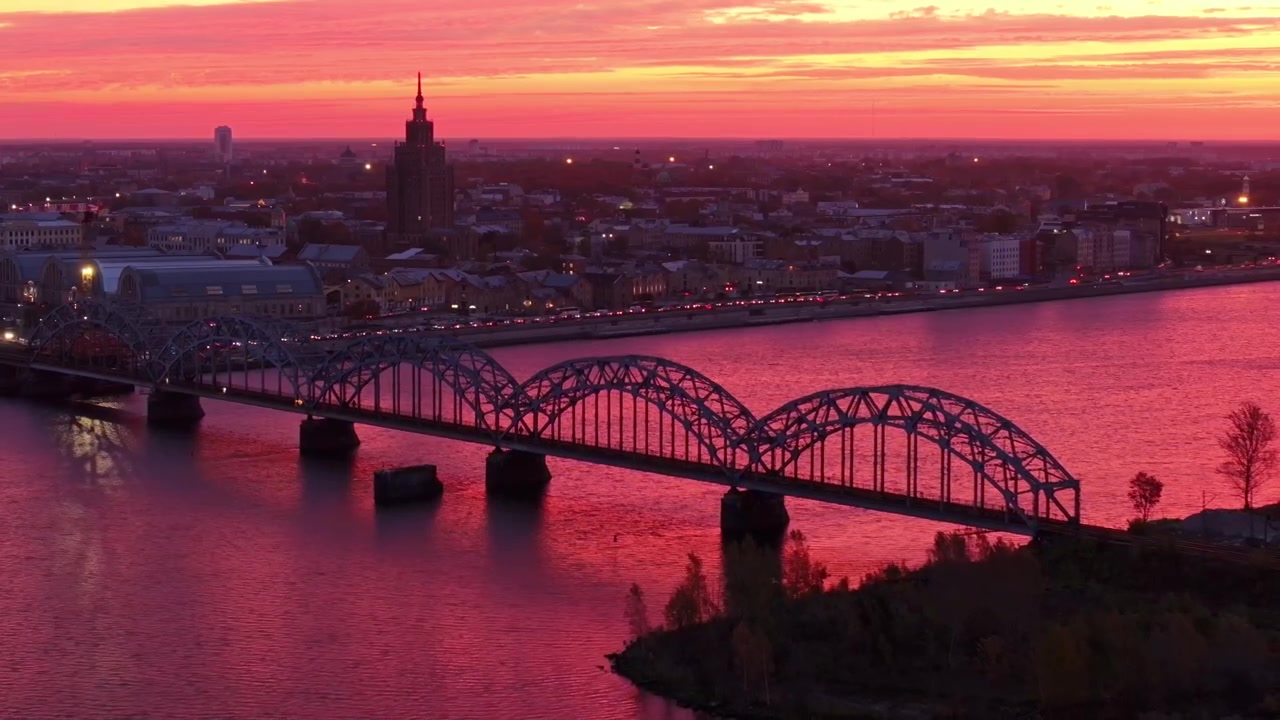 Alba autunnale infuocata su un ponte ferroviario - colori mattutini drammatici, Riga, Lettonia