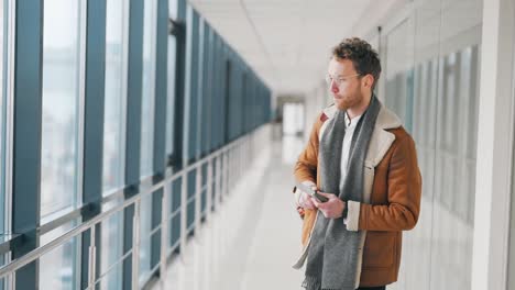 Young-man-waiting-for-a-joyful-message-on-a-smartphone