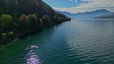 Atemberaubende-Drohnenaufnahme-Des-Attersees-In-Österreich-Mit-Waldufern-Und-Nebligen-Bergen