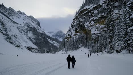a couple walking in the snow inside the banff national park under the winter weather