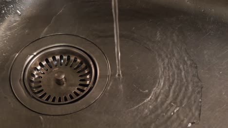 water flowing into a kitchen sink drain