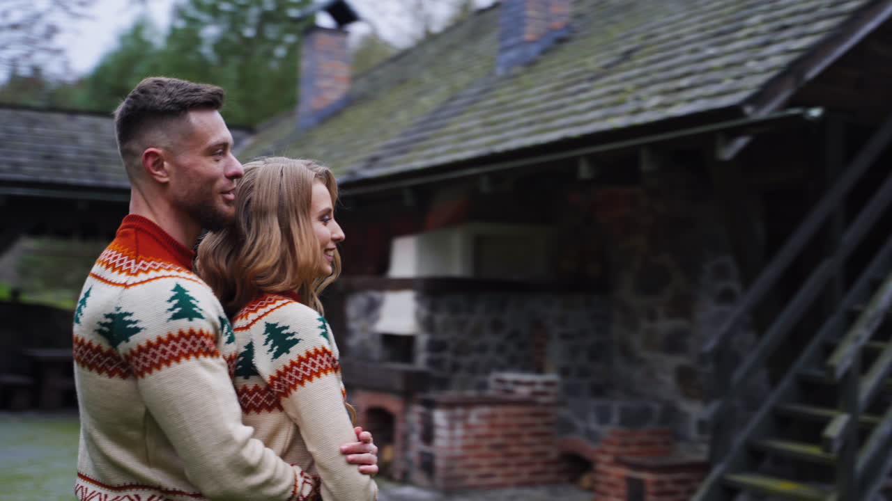 Young handsome man hugges girl outside. Beautiful couple outside at autumn nature background.