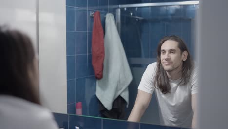 man looking in bathroom mirror
