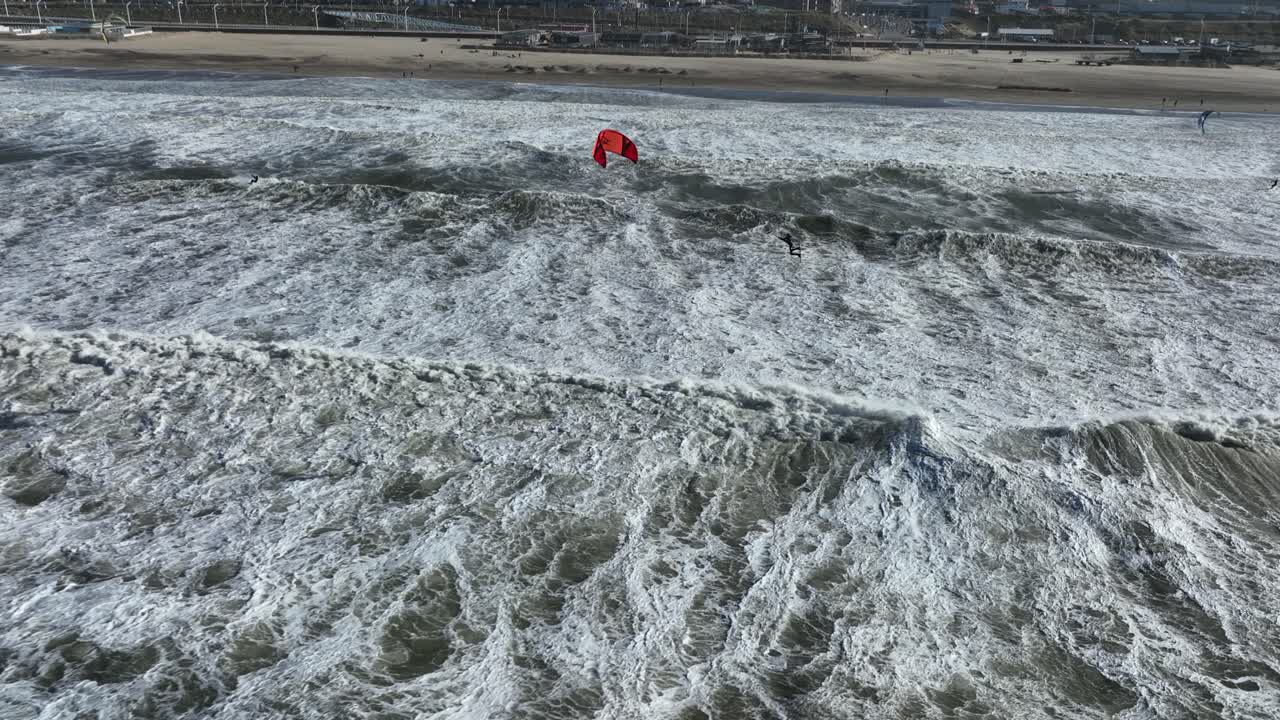 surfista de cometas atrapando aire grande en olas turbias de agua de tormenta en scheveningen