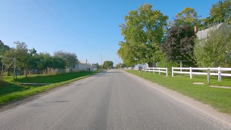 pov driving on a rural road approaching a horse and buggy in iowa amish country - kalona, iowa