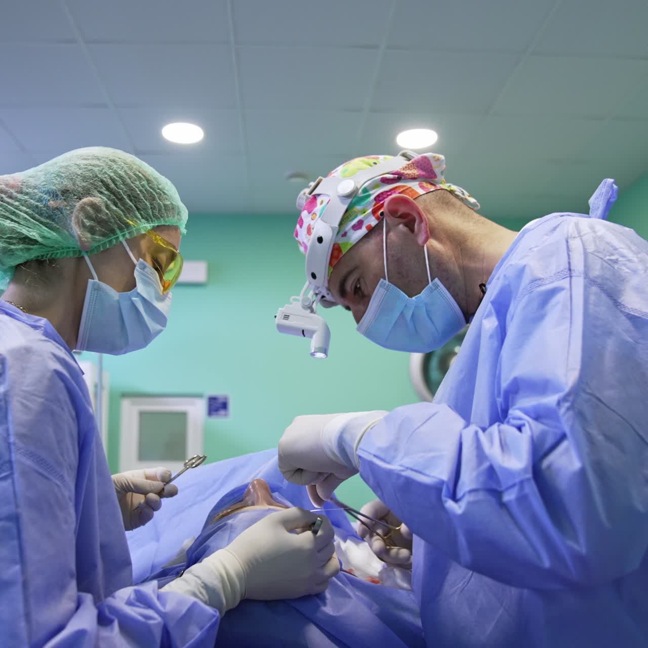 Surgeon uses thread and forceps at operation on eyelid. Assisting doctor holding the tools prepared