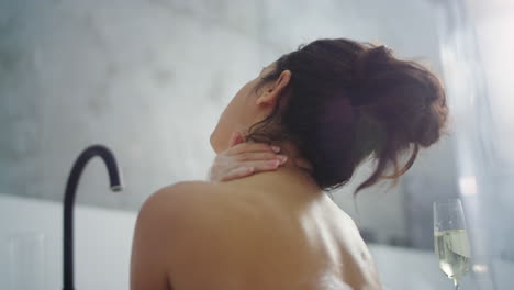 caucasian woman washing shoulder at luxury bathtub