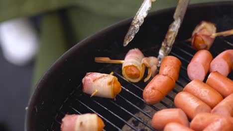 grilled bacon-wrapped sausages on a barbecue grill