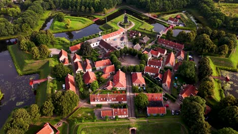 aerial view of a star-shaped fortified village with red-roofed houses and a moat