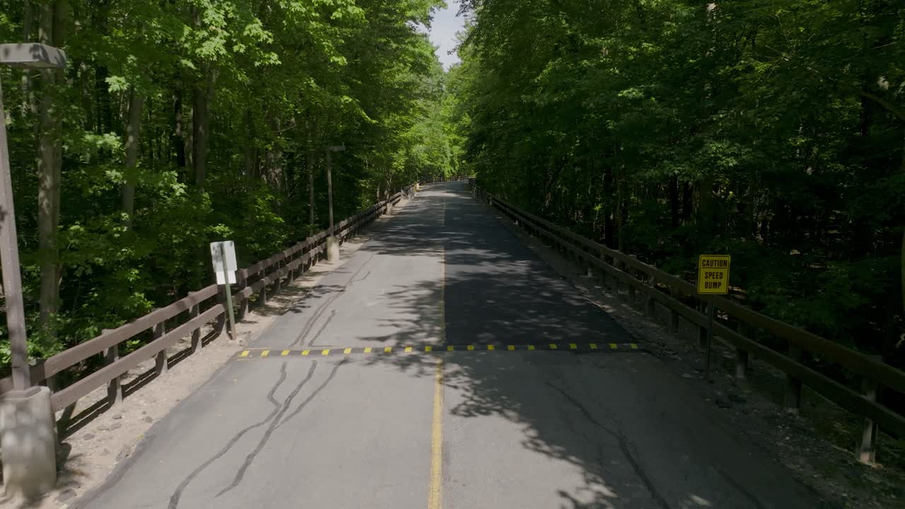 A quiet, empty back road surrounded by trees and countryside