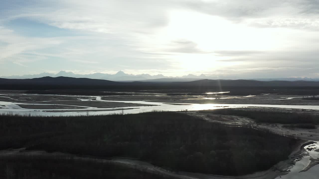vista aérea volando sobre árboles con río y montañas en segundo plano