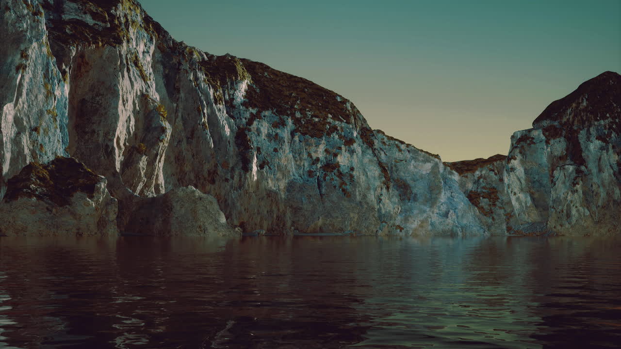 Waves lapping against the rugged cliffs at twilight near the tranquil water