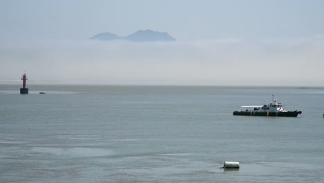 Ganghwado-island,-Fisherman's-boat-in-the-Yellow-sea,-Red-navigational-buoy-floating-in-between-islands,-copy-space-template
