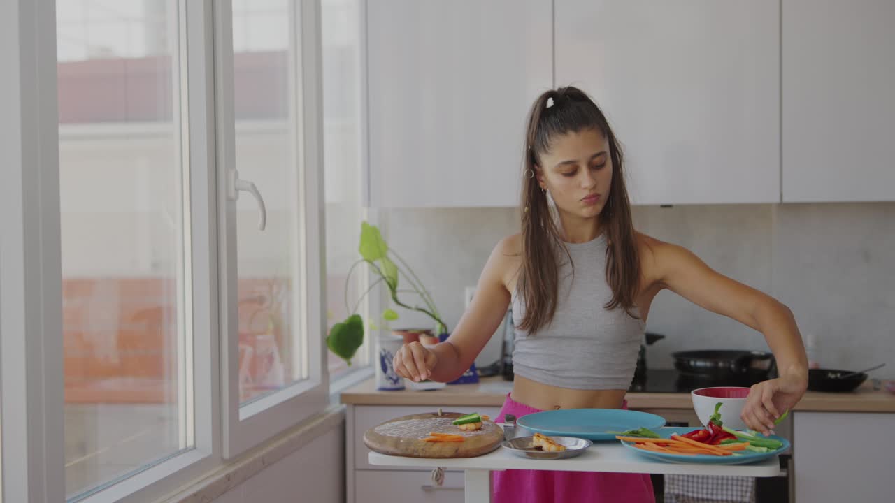 Mujer joven picando verduras frescas en una cocina luminosa