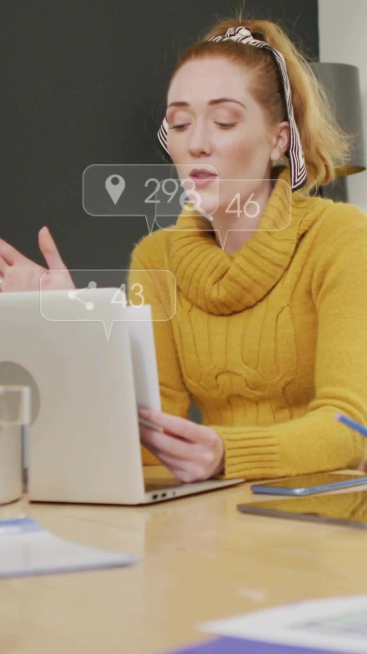 Donna che presenta una strategia di marketing, tiene in mano dei documenti, gesticola mentre avvisi fluttuanti sul laptop aggiornano le metriche.