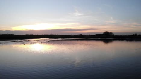 Reflexiones-Sobre-El-Lago-Tranquilo-En-Crezeepolder-Cerca-Del-Pueblo-De-Ridderkerk-En-Los-Países-Bajos-Durante-El-Amanecer