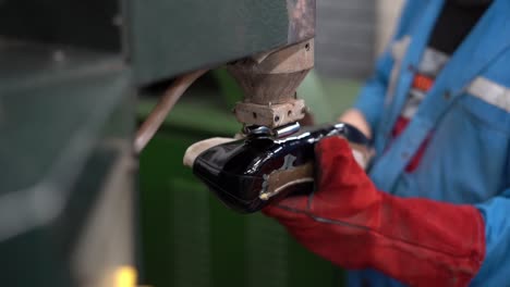 a craftsman handmade a shoe by a machine, close up shot, insert shot