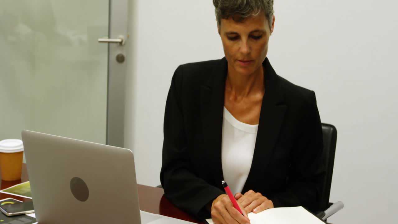 mujer de negocios escribiendo en un diario 4k