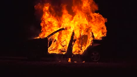 burning car at night, left side, medium long shot, complete view