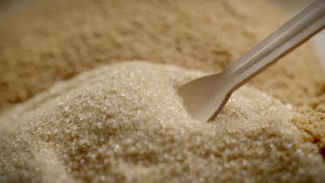 close up slow motion shot of wooden spoon scooping brown sugar