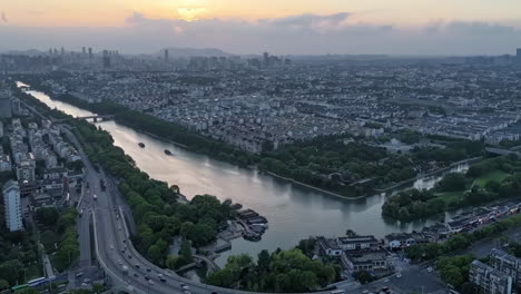 Avenue-City-highway-crossroad-traffic-flow-landscape-sunrise-morning-scene-near-small-lake-river,-Time-Lapse-Heavy-traffics-jam-cars-flowing-at-open-hour-business