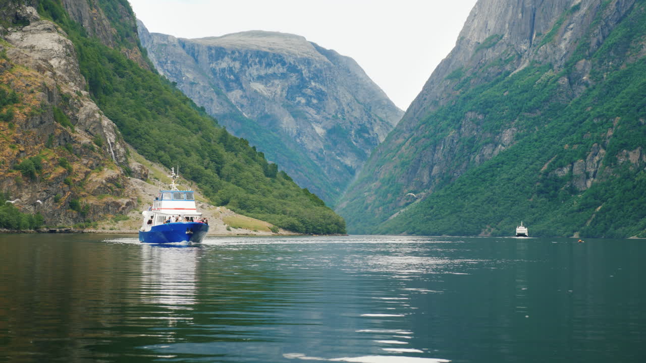Ein kleines Kreuzfahrtschiff fährt entlang des malerischen Fjords in Norwegen. Reisen und Tourismus in Skandinavien. 4K