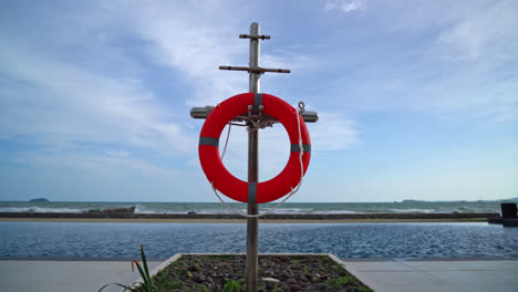 lifebuoy ring near swimming pool with sea background