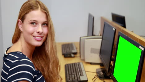 estudiante feliz usando la computadora y sonriendo a la cámara