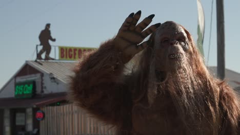 Bigfoot-Sasquatch-Agitando-La-Mano-En-El-Aire-Disfrazado-Caminando-Sonriendo-Aterrador-Metraje-De-Halloween
