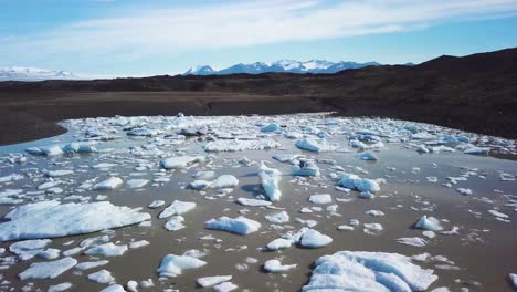 slow aerial across the massive glacier lagoon filled with icebergs at fjallsarlon iceland suggests global warming and climate change 16