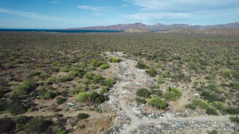 Basura-Esparcida-Por-El-Paisaje-Desértico-De-Mulegé,-Baja-California-Sur,-México---Toma-Aérea-De-Retroceso