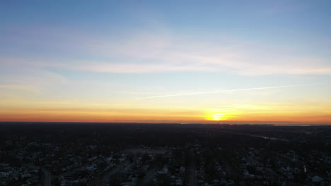 An-aerial-shot-over-a-suburban-neighborhood-during-a-golden-sunrise