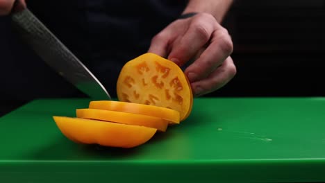 chef cutting yellow tomatoes